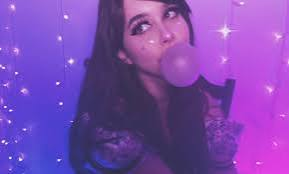 YouTube commentator June Lapine (Shoe0468) blowing a bubblegum bubble under purple lighting against a backdrop of fairy lights.