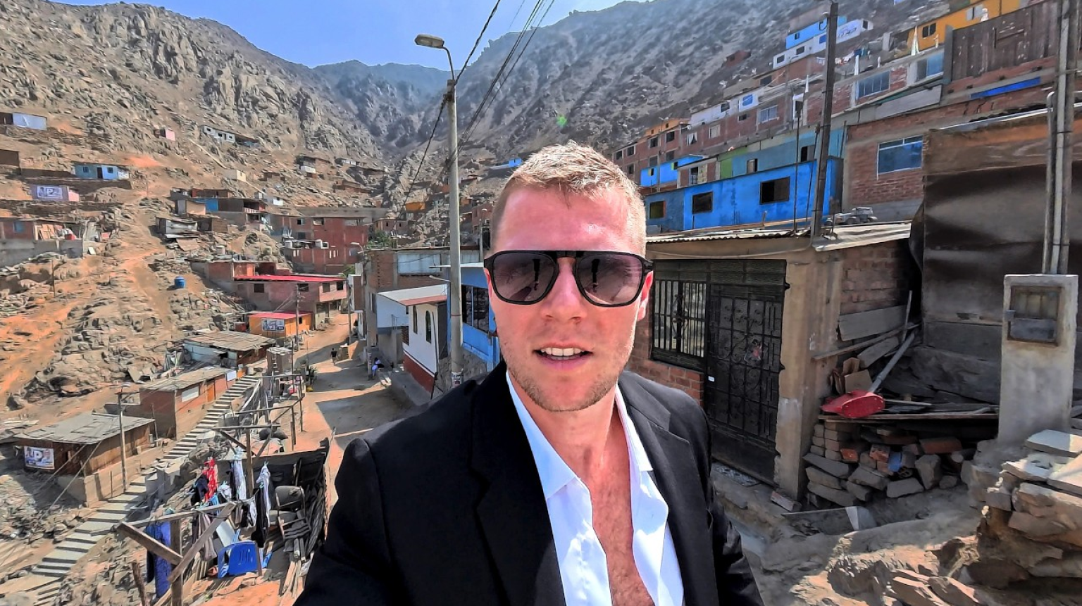Panoramic view overlooking brick homes and informal settlements built on the rocky slopes of San Juan de Lurigancho in Lima, Peru.