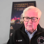 Former Congressman Kurt Weldon speaking during a video interview wearing a black embroidered firefighter jacket.