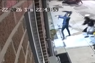 Surveillance camera footage timestamped March 22, 2026, showing suspect aiming a firearm on the sidewalk during a shooting incident on North 22nd Street in Philadelphia's 22nd Police District.