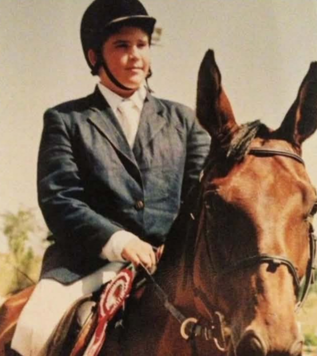 Resurfaced Childhood Photo of Hasan Piker Triggers Online Debate Over Wealth and Authenticity 1 Resurfaced childhood photograph of streamer Hasan Piker wearing a black riding helmet and suit jacket while riding a brown horse with equestrian show ribbons attached.